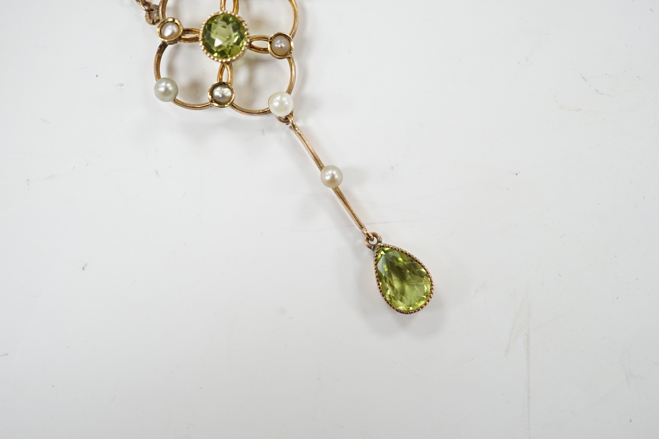 An Edwardian 9ct, peridot and seed pearl set drop pendant necklace, 49cm, gross weight 3.5 grams.